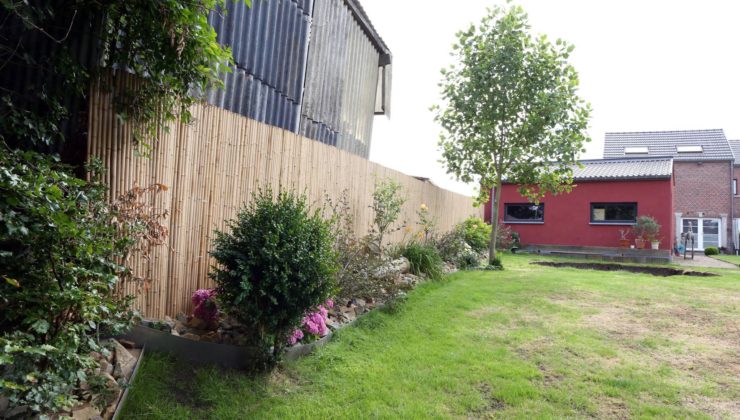 Maison en brique rouge avec une clôture en bois
