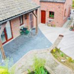 Maison avec une terrasse en pierre et parquet