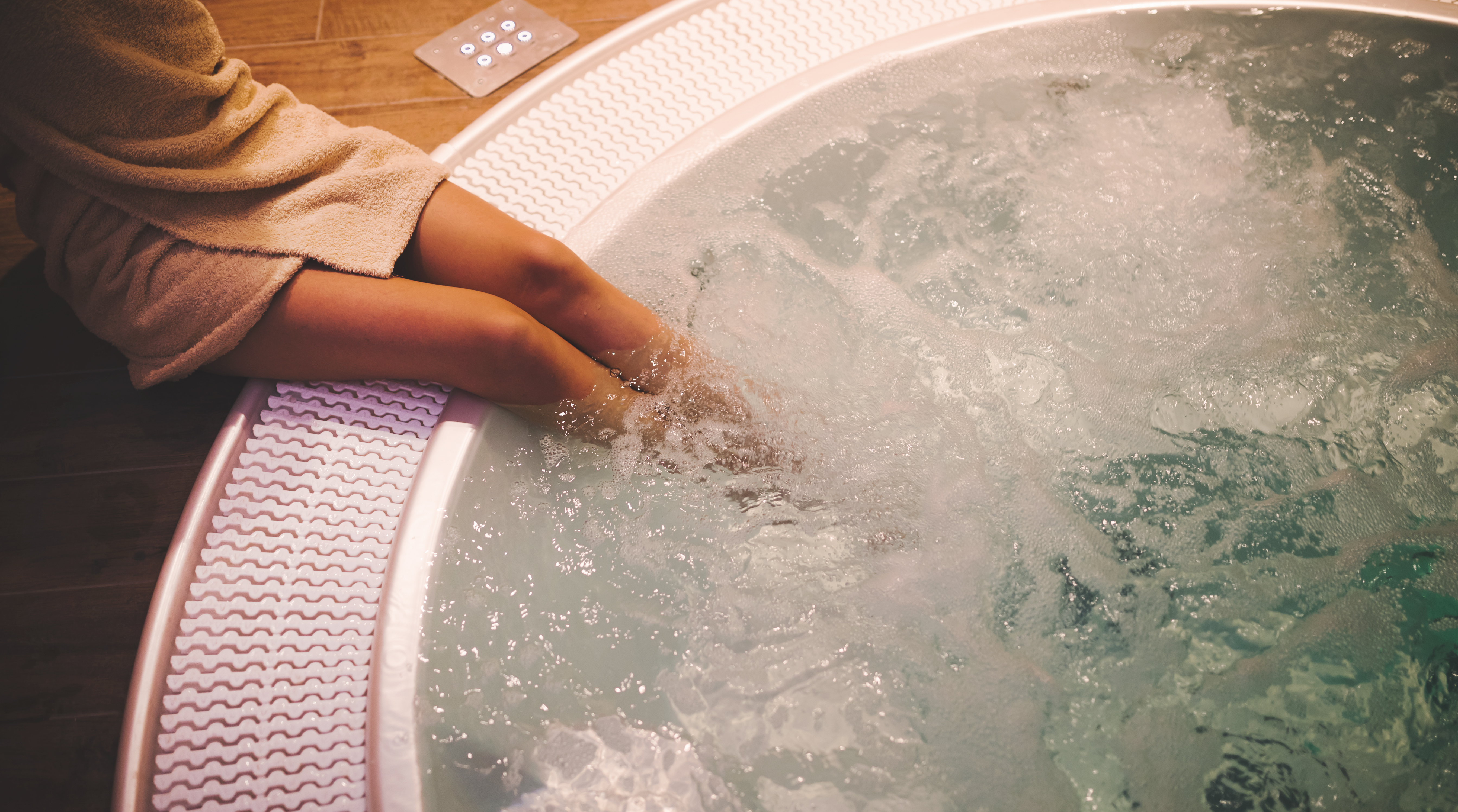 Femme plongeant ses jambes dans un Jacuzzi encastré